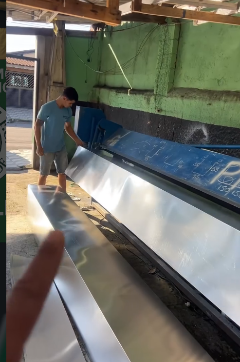 Profissional trabalhando com uma chapa de alumínio na oficina
